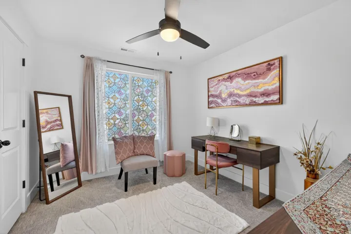 Office area featuring light carpet and a ceiling fan