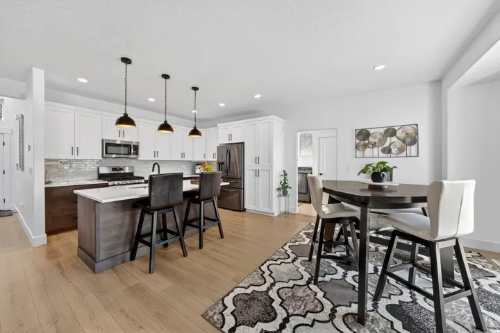 Dining area with light wood-type flooring, washer / clothes dryer, a textured ceiling, and recessed lighting