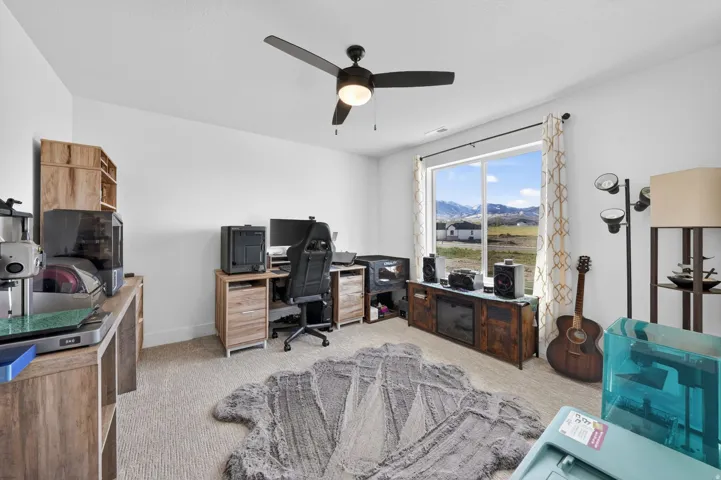 Office area with light carpet and ceiling fan