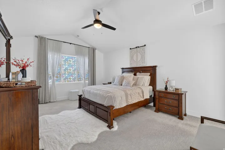 Bedroom featuring light colored carpet and ceiling fan