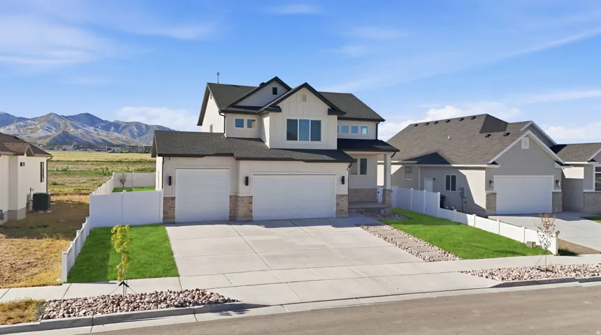 View of front of house featuring stone siding, driveway, and an attached garage