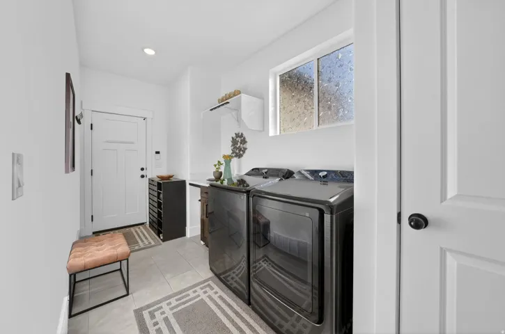 Laundry room with light tile patterned floors, separate washer and dryer, and recessed lighting
