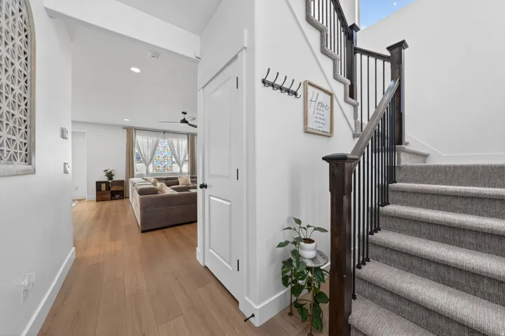 Staircase with wood finished floors, a ceiling fan, and recessed lighting