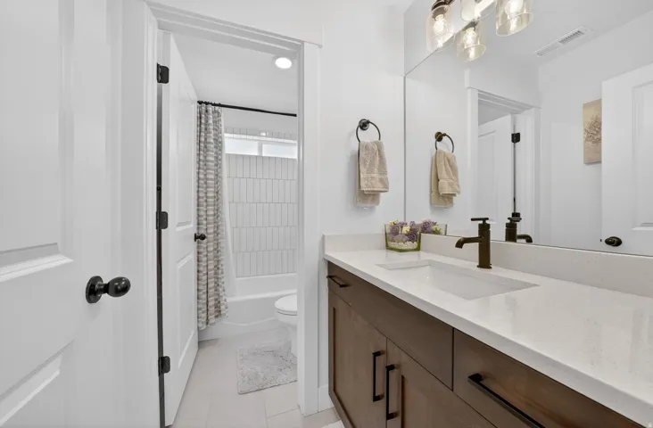 Full bathroom featuring vanity, shower / tub combo with curtain, and light tile patterned flooring