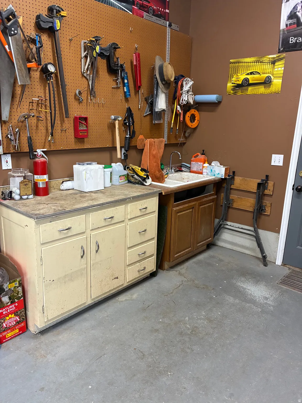 Extra deep 3rd car garage with workbenches and mechanic's pit. Tons of shelves and storage for tools, sink and counter top for working hard and cleaning up.