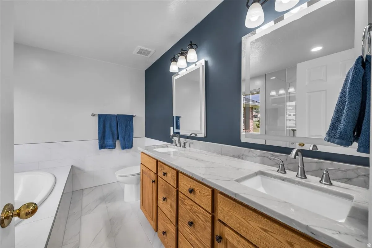 Owner's suite bathroom with double vanity, jetted tub, and separate shower.