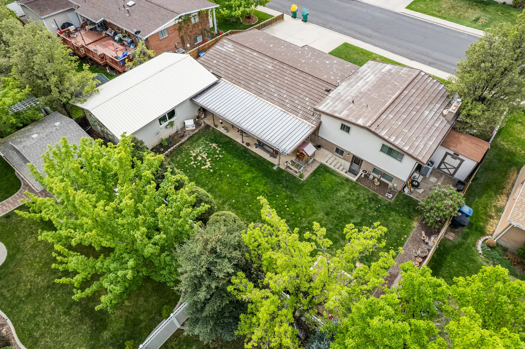 View of backyard, covered patio, shed and detached garage.