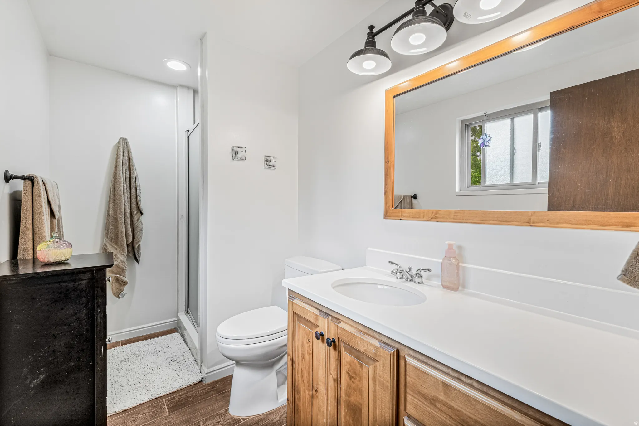 Bathroom featuring a shower stall, vanity, dark wood-type flooring, and recessed lighting
