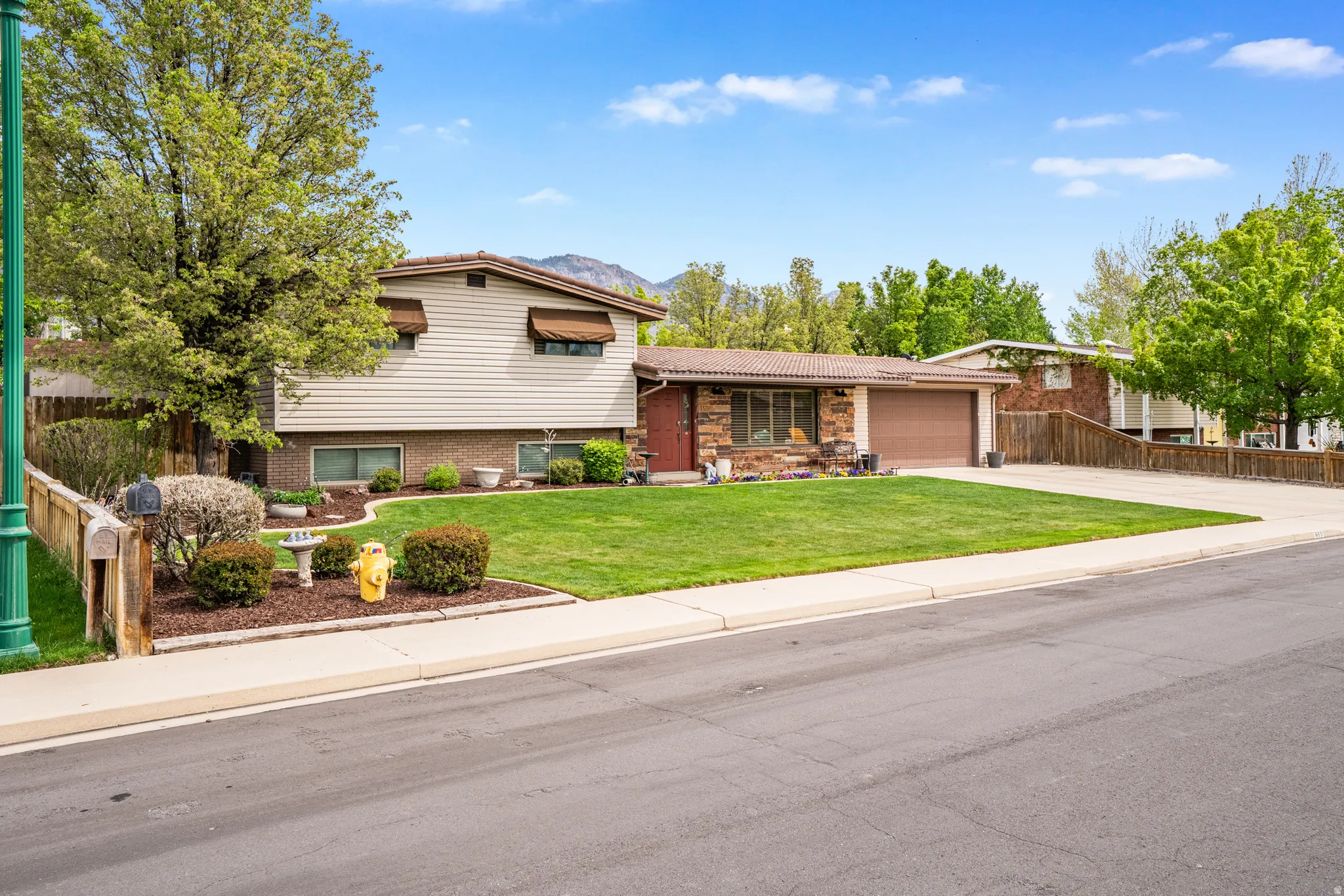 4 level home featuring a garage, driveway, a metal roof