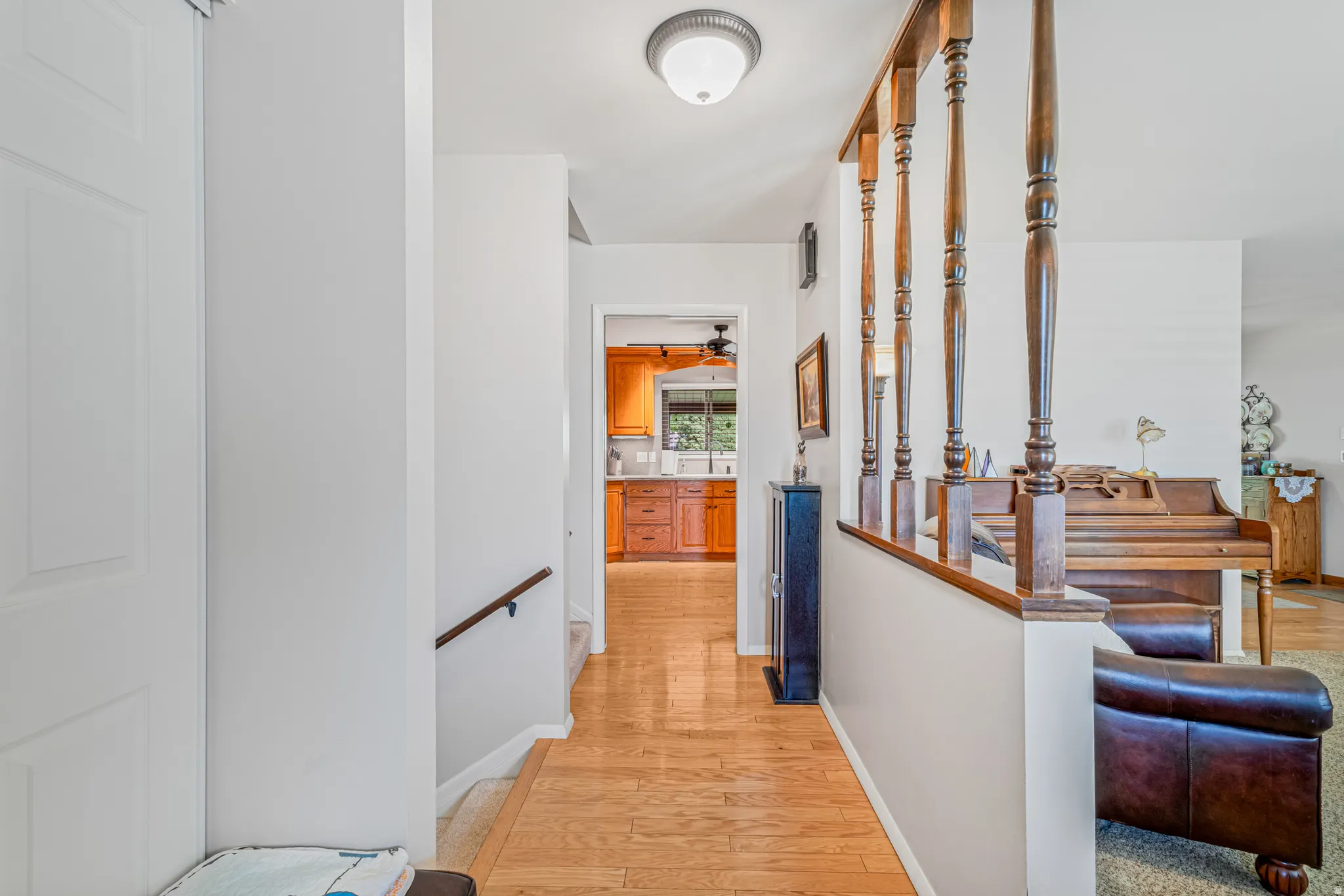 Hallway with an upstairs landing and light wood-style floors