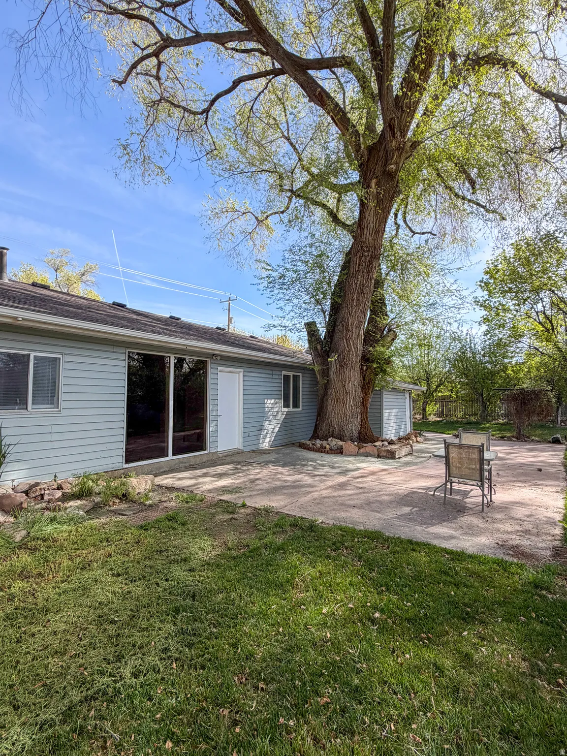 Rear view of property featuring a lawn and a patio area