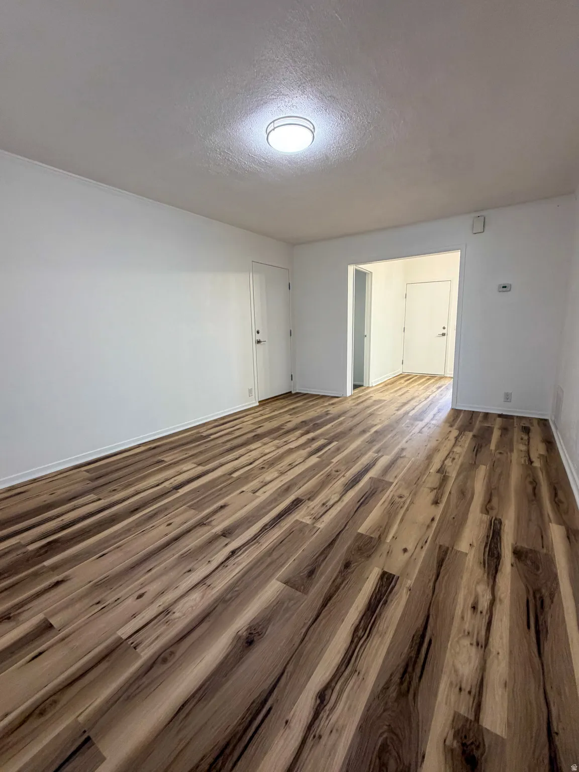 Unfurnished room featuring a textured ceiling and wood finished floors