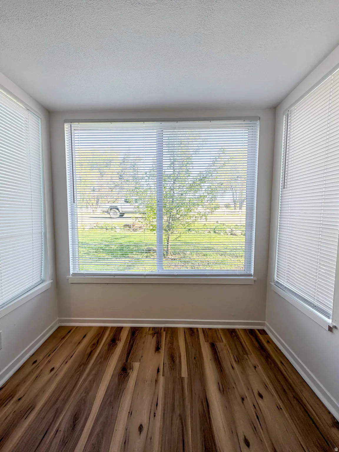 Spare room featuring dark wood-type flooring and a textured ceiling