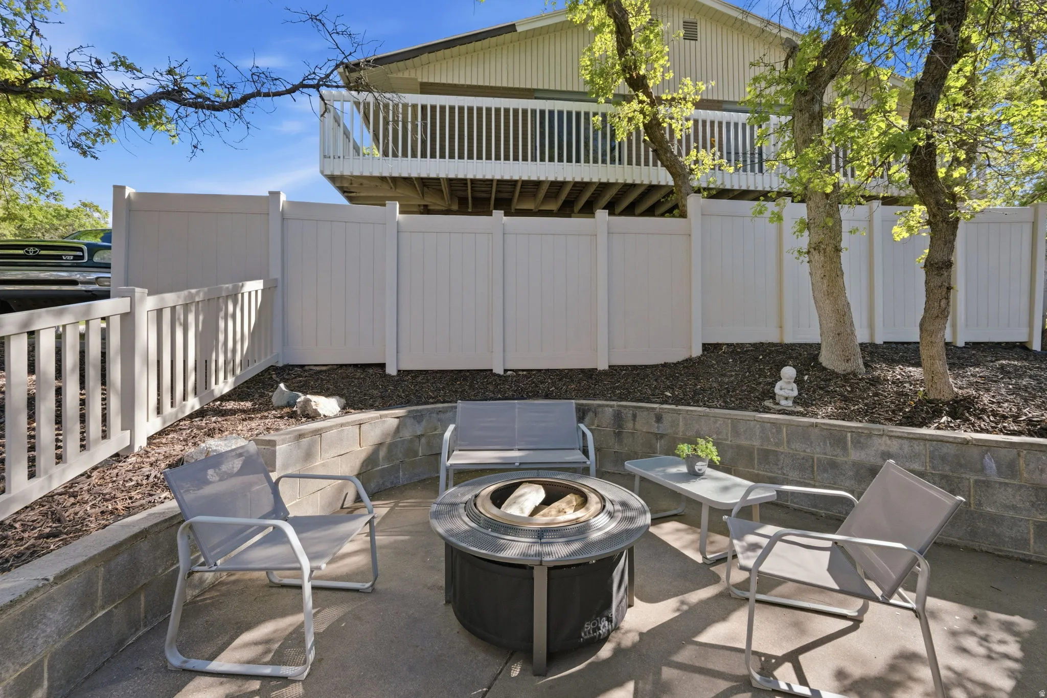 Fenced backyard with a fire pit and a patio