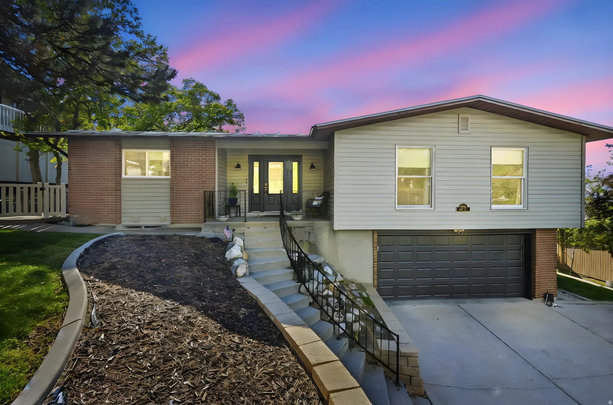 Ranch-style house featuring a garage, brick siding, concrete driveway, and french doors