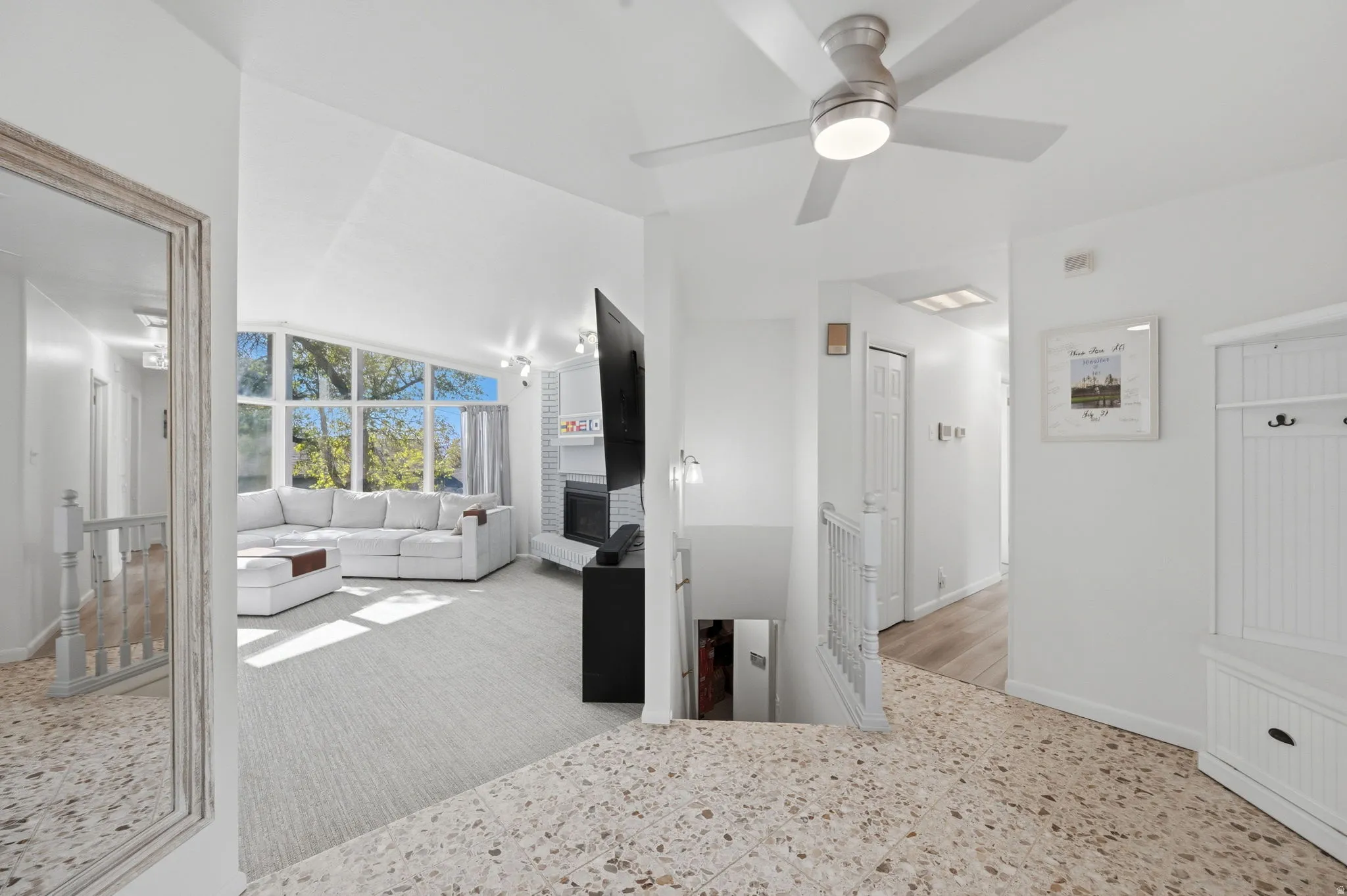 Unfurnished bedroom featuring lofted ceiling, ceiling fan, and a large fireplace