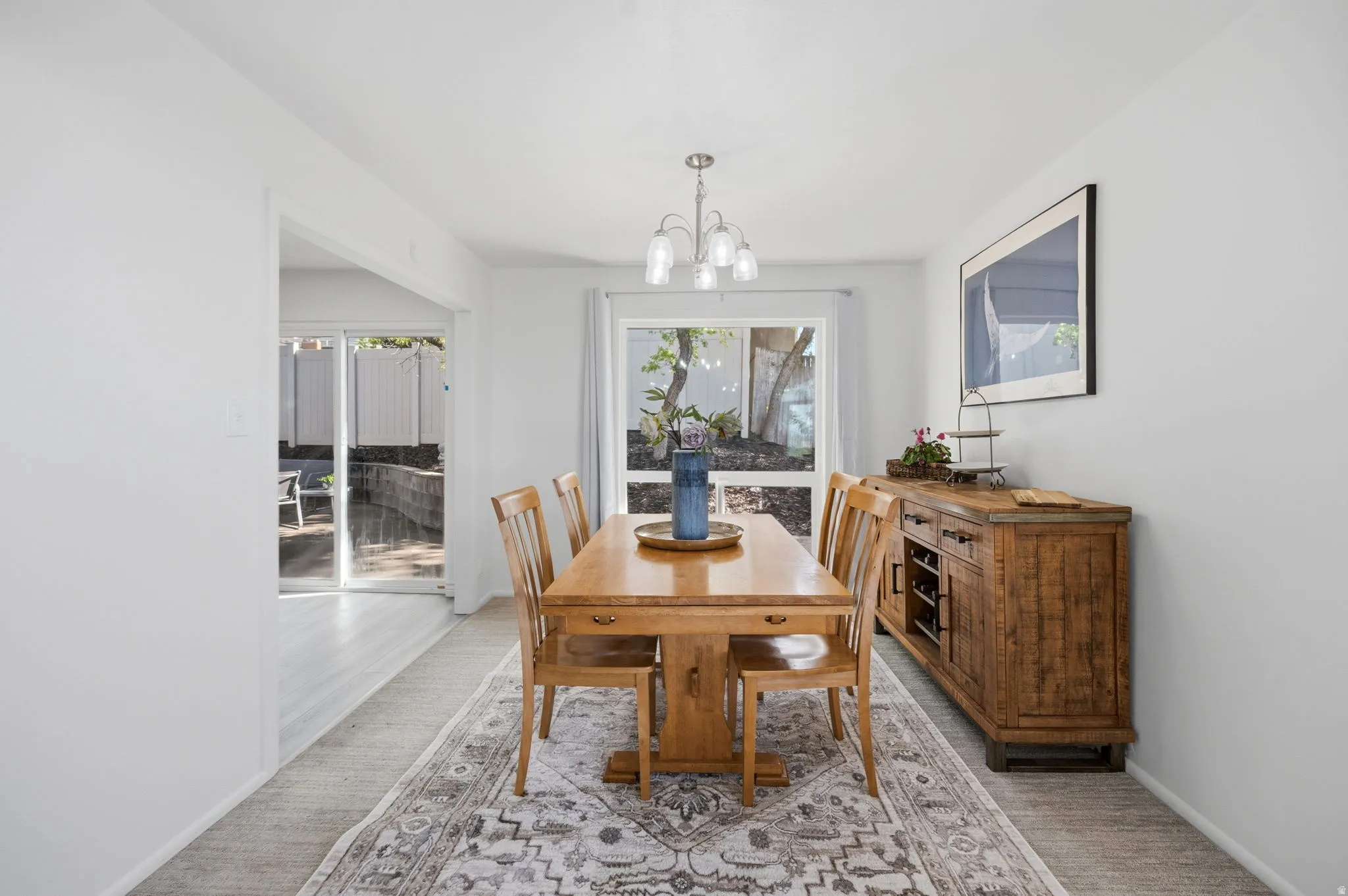 Dining space featuring suspended lighting and light colored carpet