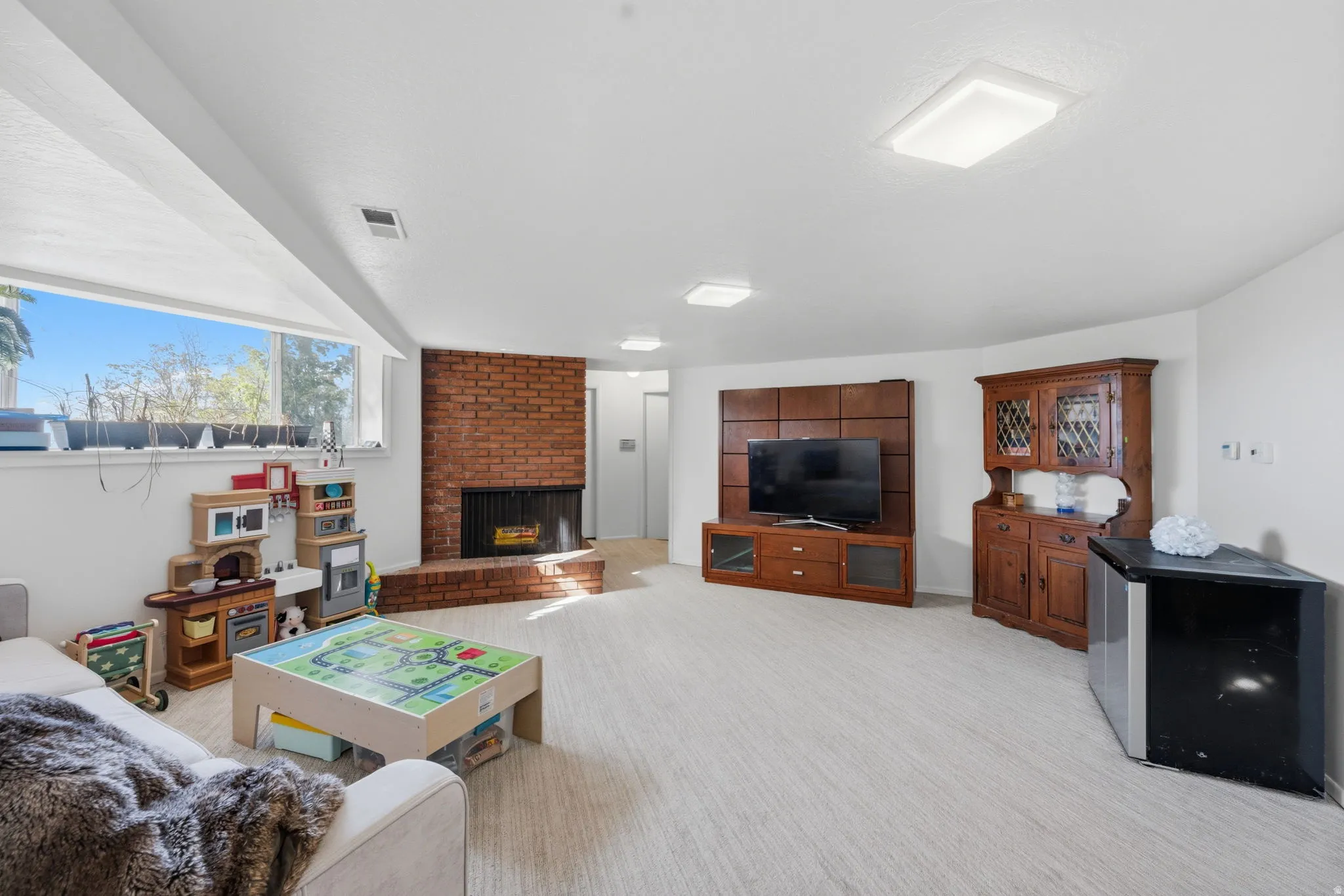 Living room featuring a brick fireplace and light carpet