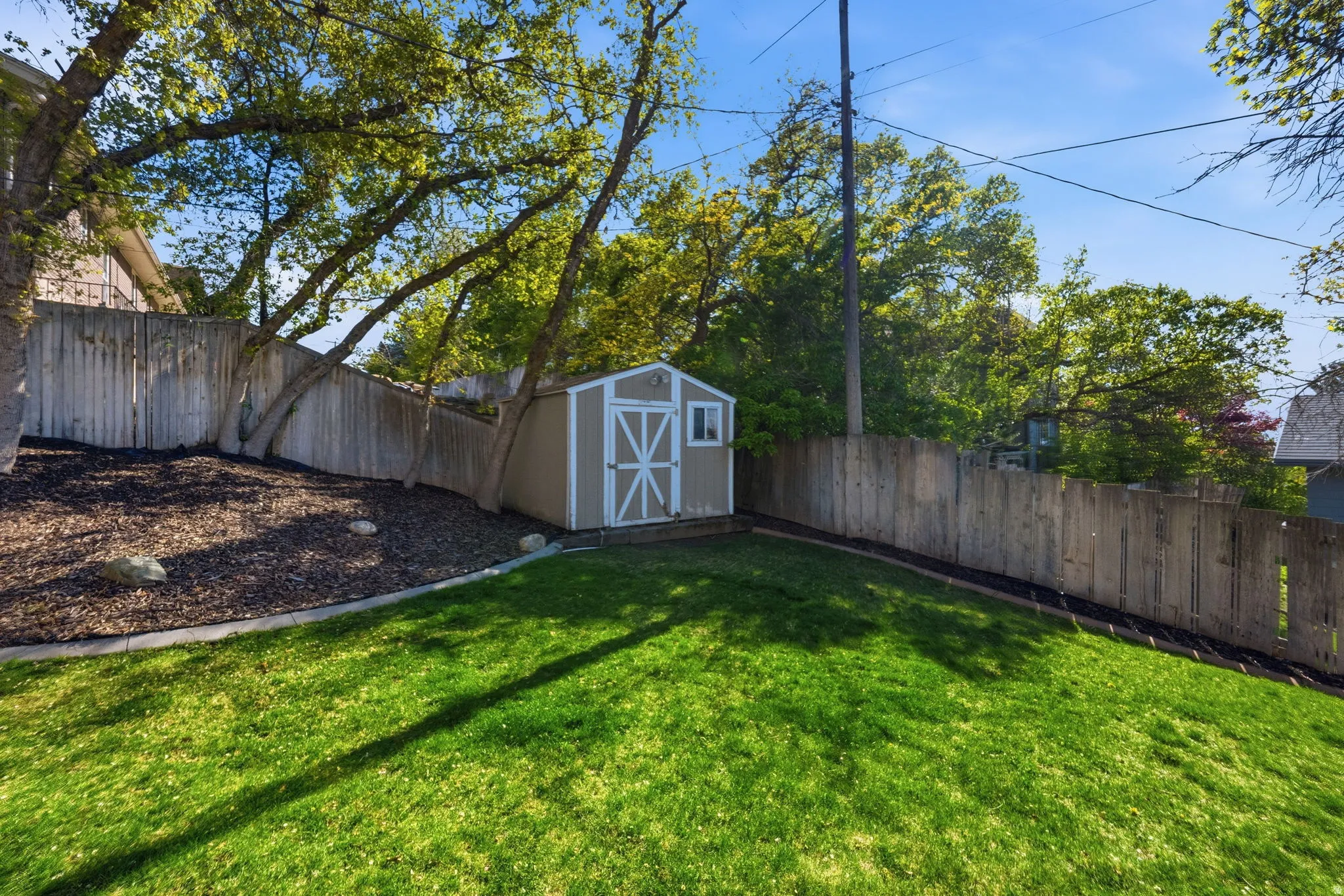 Fenced backyard with a storage unit