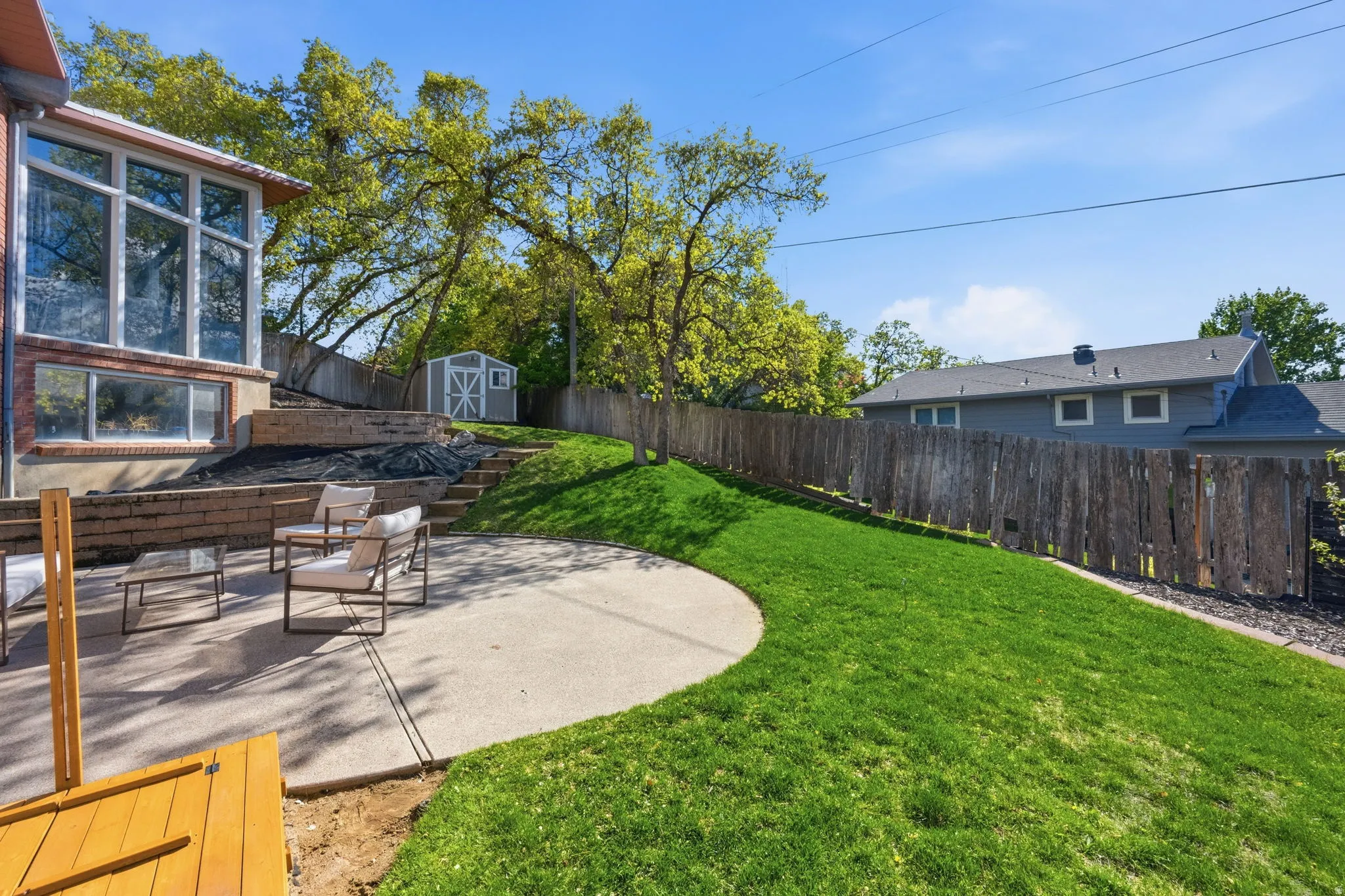 Fenced backyard featuring a patio and a storage unit