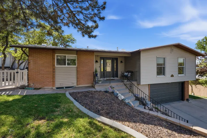 Ranch-style home featuring a garage, brick siding, and driveway
