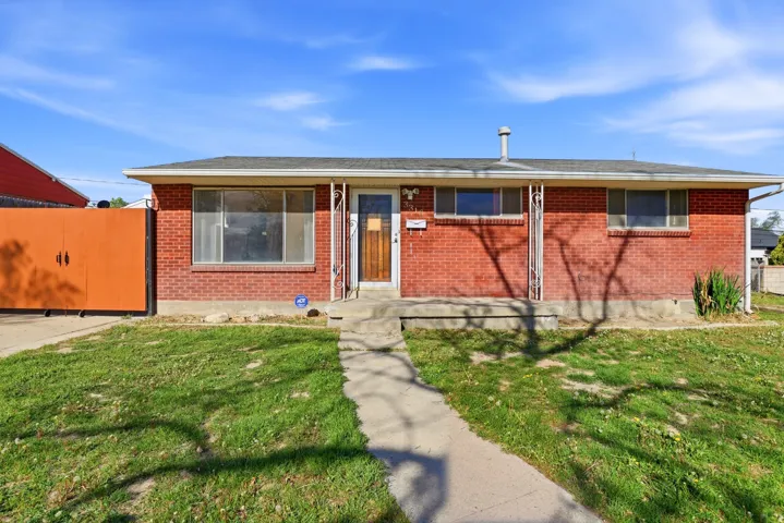 View of front of home with brick siding and a gate