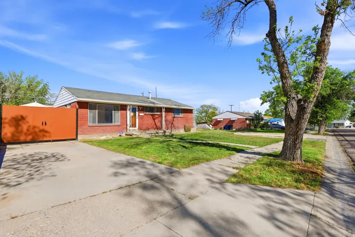 View of front of property featuring a front lawn and brick siding