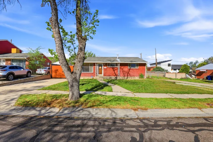 View of front of house with brick siding and concrete driveway