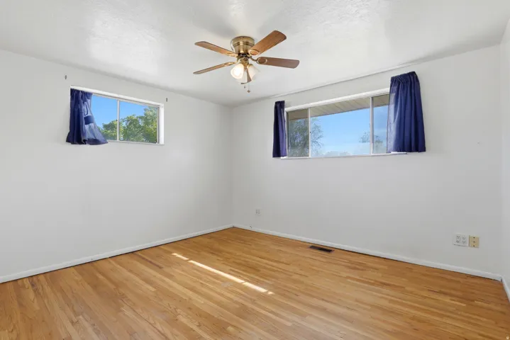 Unfurnished room with hardwood / wood-style floors and ceiling fan