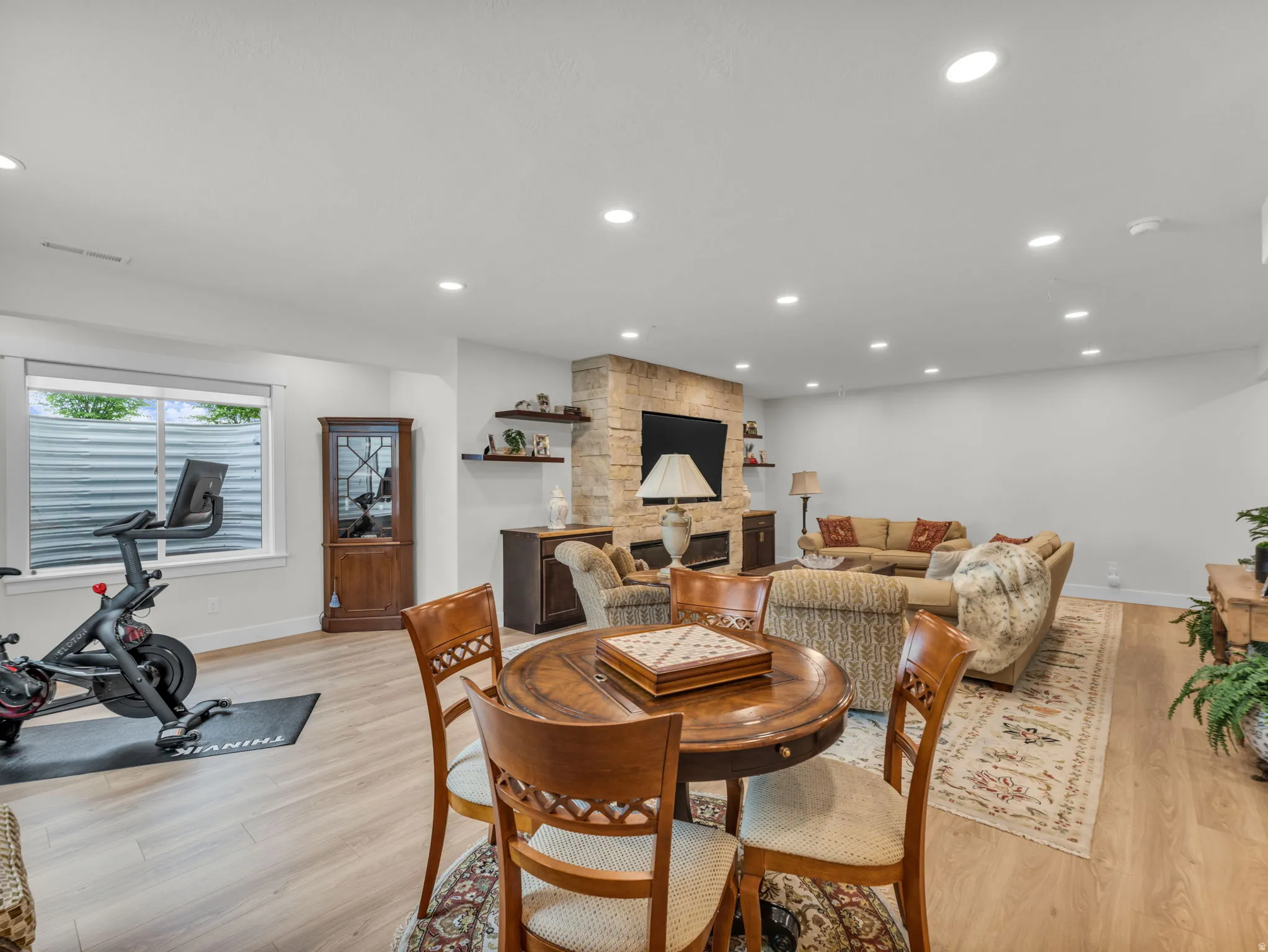 Dining room featuring light wood finished floors, a fireplace, and recessed lighting