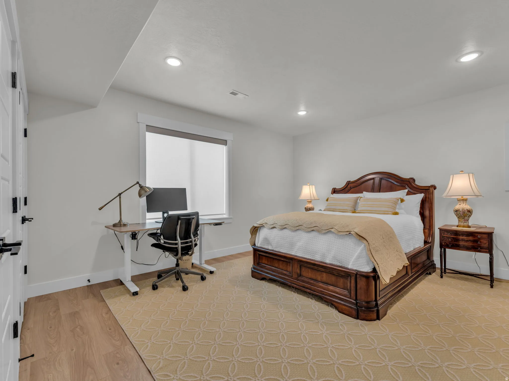 Bedroom featuring an office area, light wood finished floors, and recessed lighting