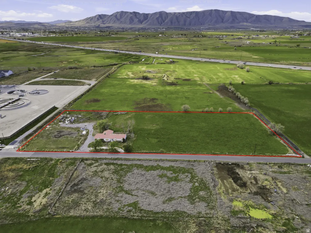 Aerial view of sparsely populated area with property parcel outlined and mountains