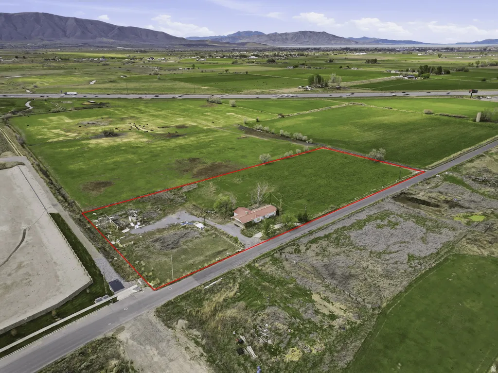 Aerial view of sparsely populated area featuring property boundaries highlighted and a mountainous background