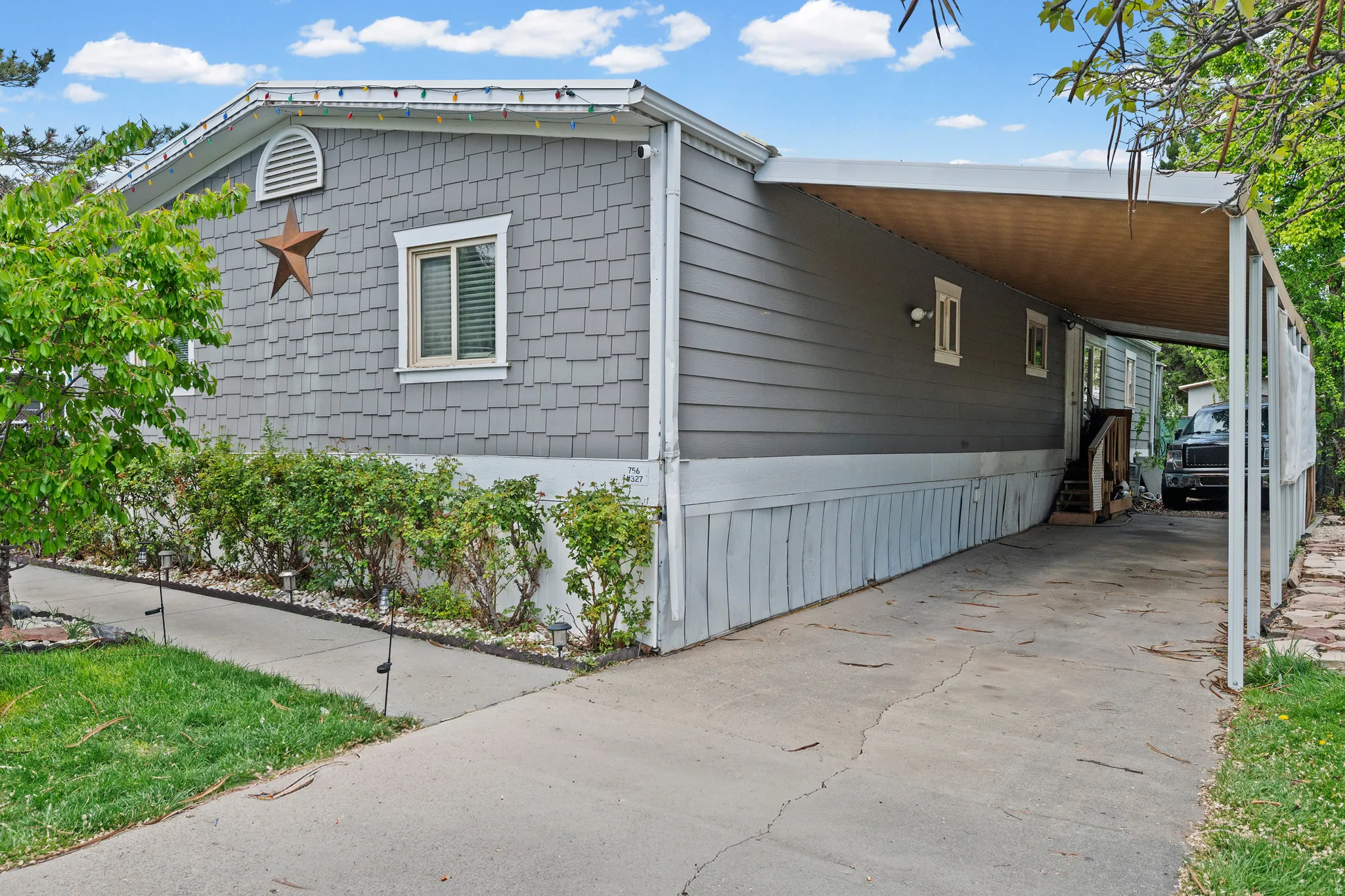 View of home's exterior with an attached carport and concrete driveway