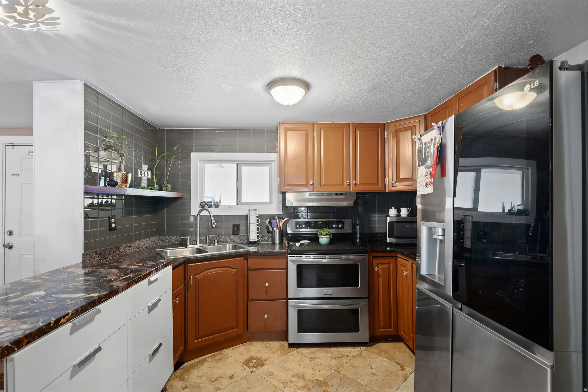 Kitchen with stainless steel appliances, backsplash, wood finish cabinetry, light tile patterned floors, and open shelves