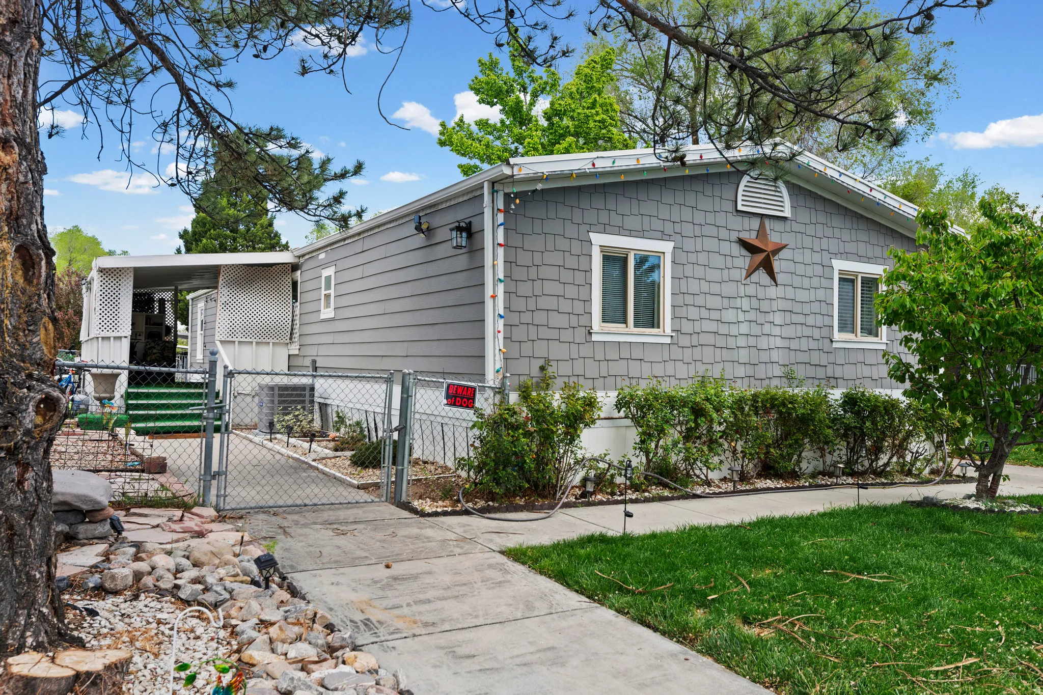 View of side of home with a gate and a central air condition unit