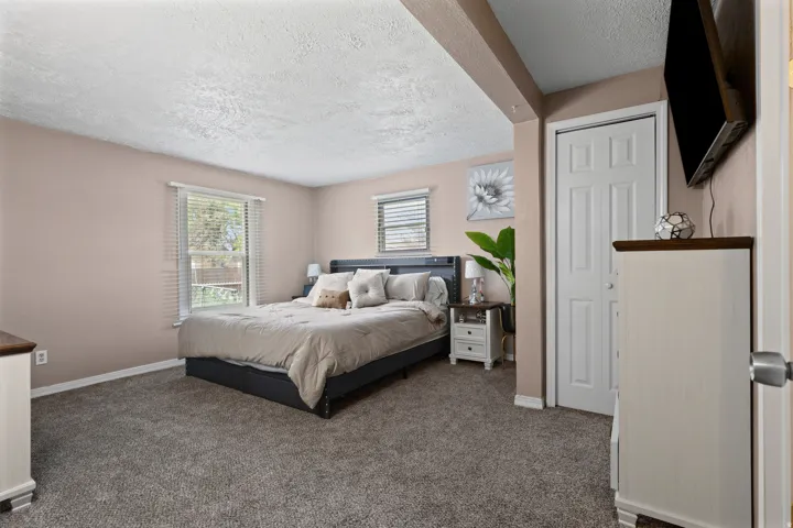 Bedroom with a textured ceiling and dark colored carpet