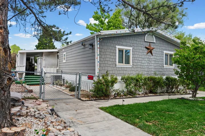 View of side of home with a gate and a central air condition unit