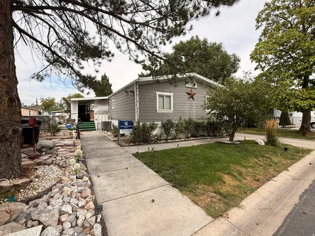 Two-tone siding exterior with a concrete walkway and mature landscaping