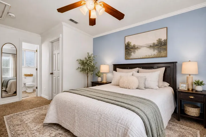 Carpeted bedroom featuring a wooden ceiling fan with integrated lighting, a dark wood-finish headboard, and crown molding