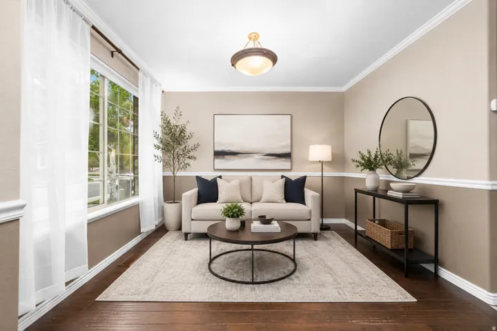 Spacious room with wood-finish flooring, two-tone wall paint, white crown molding, and large picture windows