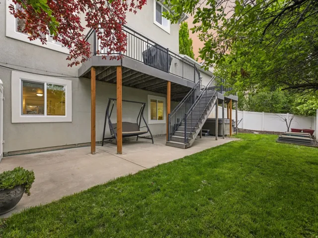 Back of house with a patio, stucco siding, a deck, and a fenced backyard