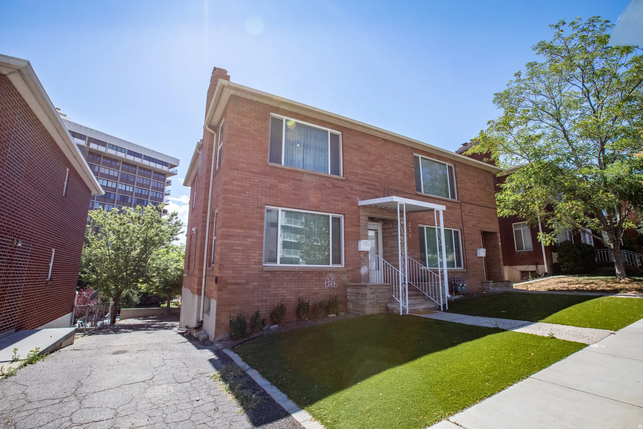 Traditional home featuring brick siding, a chimney, and a front lawn