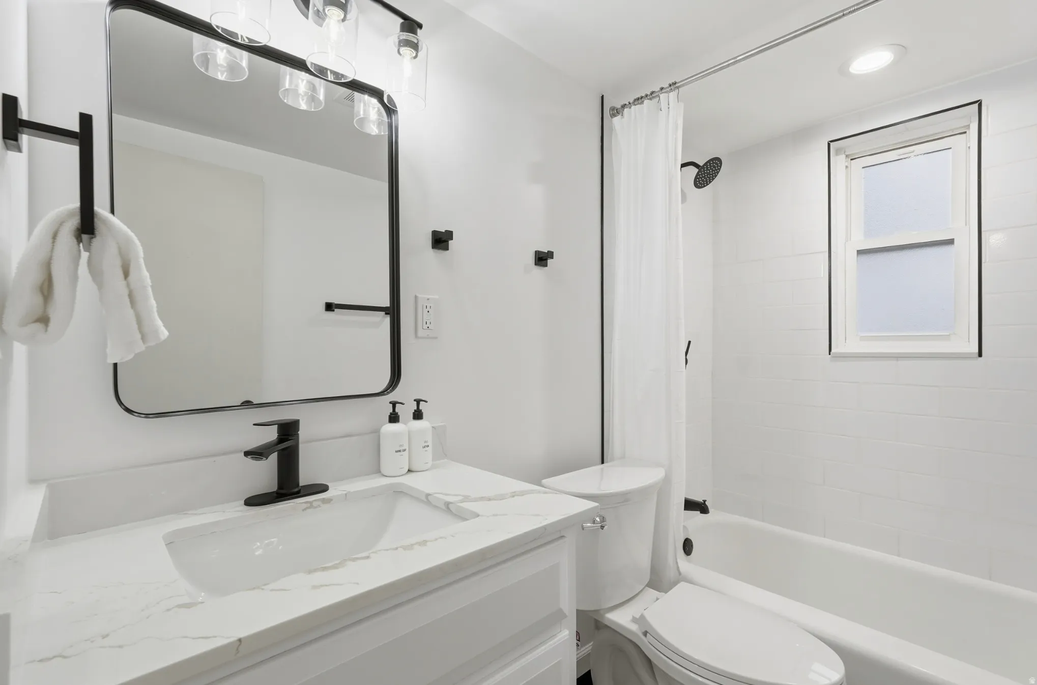 Bathroom featuring vanity, shower / bath combo with shower curtain, and recessed lighting