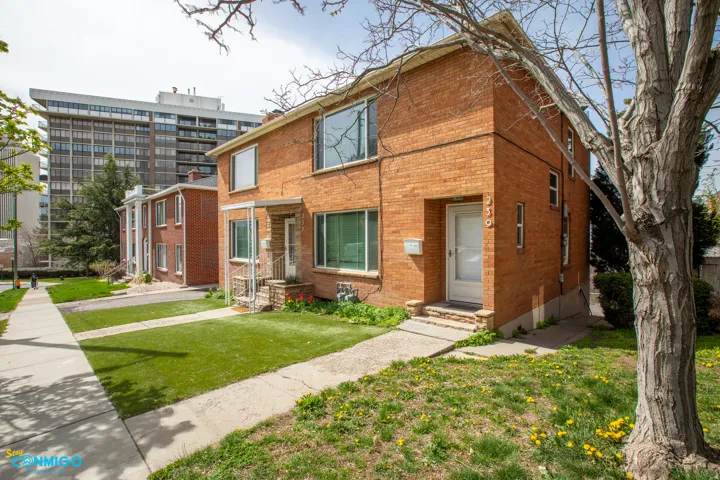Traditional home featuring brick siding and a front lawn