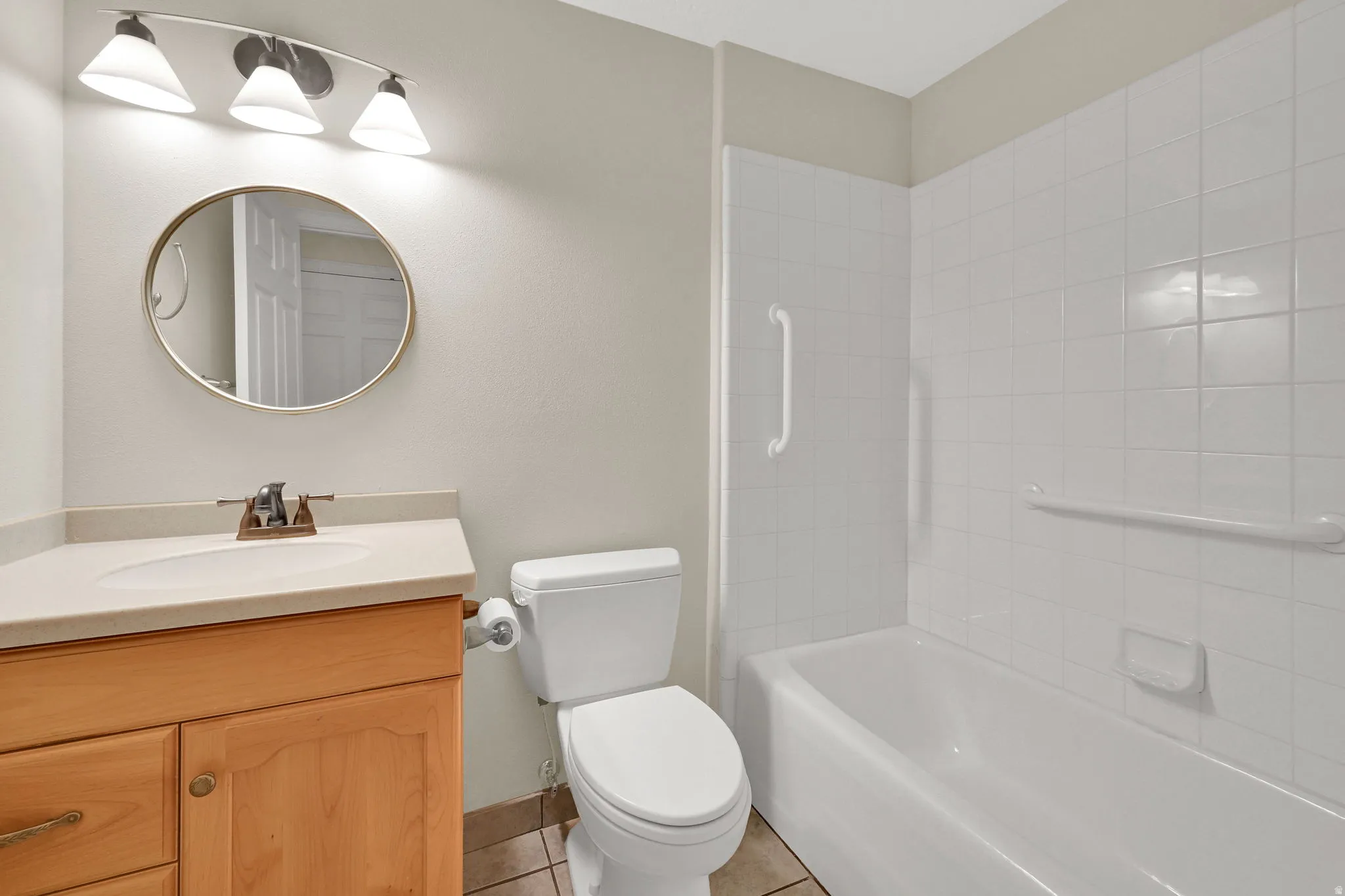 Hall bath is clean, bright, and equipped with hand rails for added safety