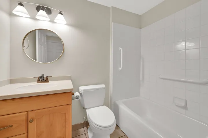 Hall bath is clean, bright, and equipped with hand rails for added safety
