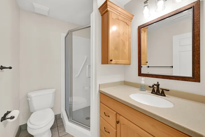 Primary bath is clean and workable, with step in shower and storage
