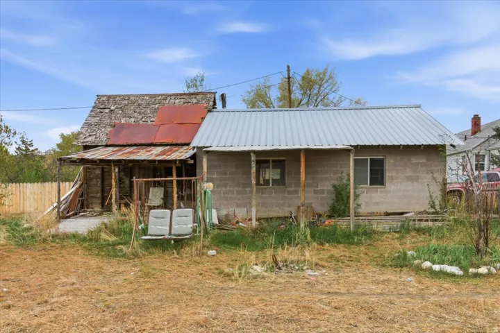 Rear view of property featuring a metal roof and concrete block siding