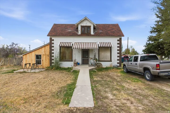View of front facade featuring a front yard and roof with shingles